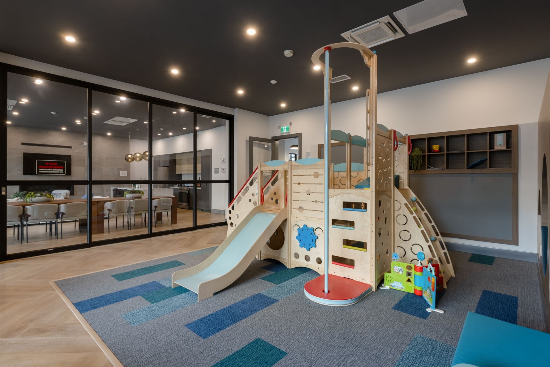 Highstreet Village – indoor amenity room with children's play structure adjoining the residents' lounge
